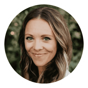 Portrait of a smiling Caucasian woman with wavy brown hair, green eyes, and a natural outdoor backdrop for a vibrant, engaging profile image.