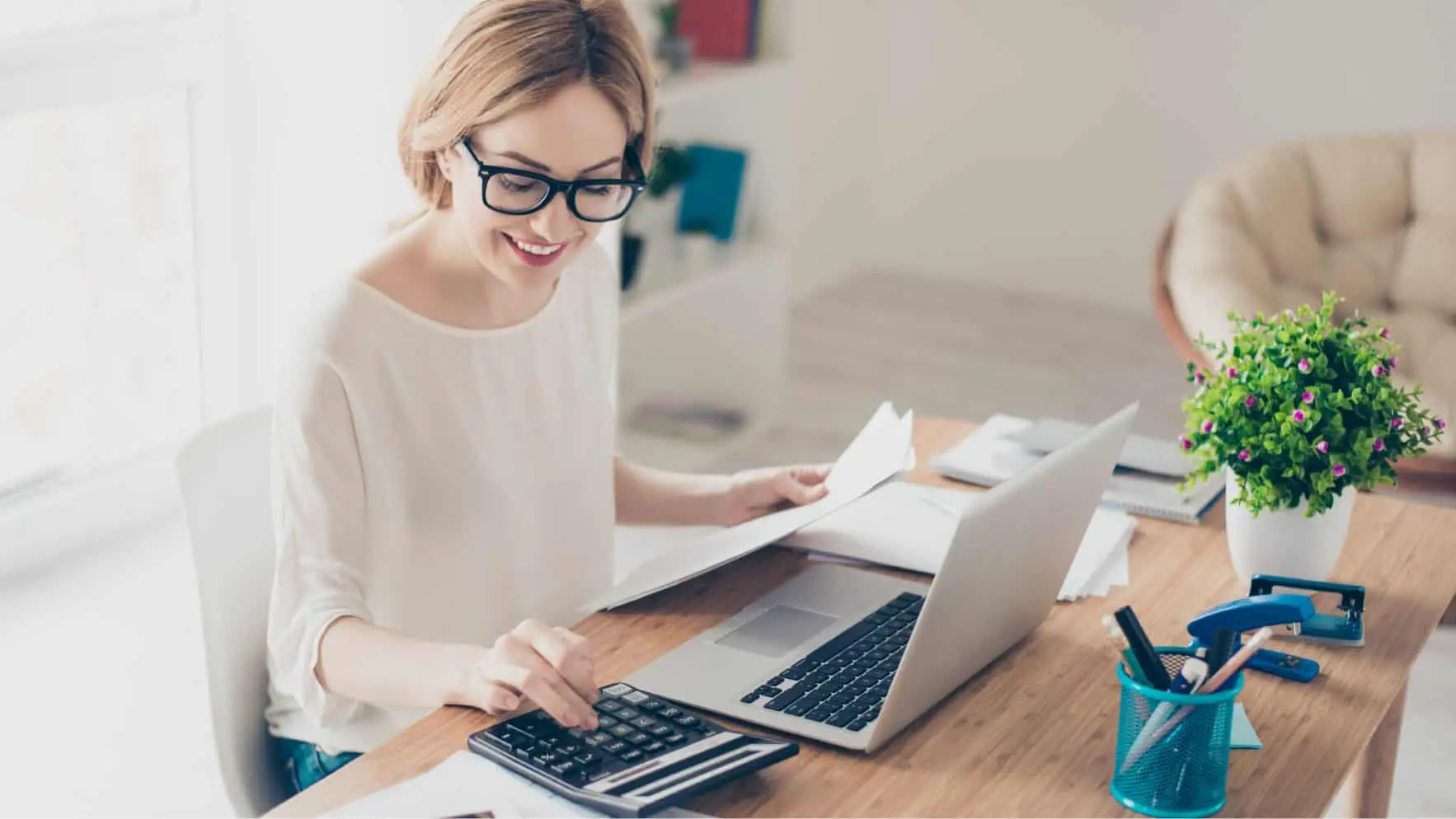 Small business owner calculating accounting costs while reviewing financial documents