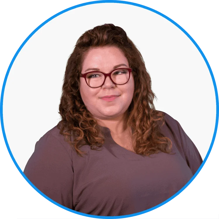 Professional woman smiling with curly hair, wearing glasses and a purple blouse, on a white and blue background.