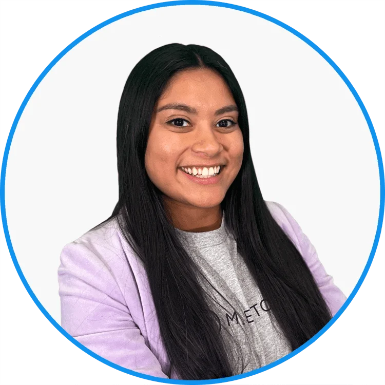 Smiling young woman with long black hair wearing a purple blazer and a grey t-shirt, set against a white circular background.