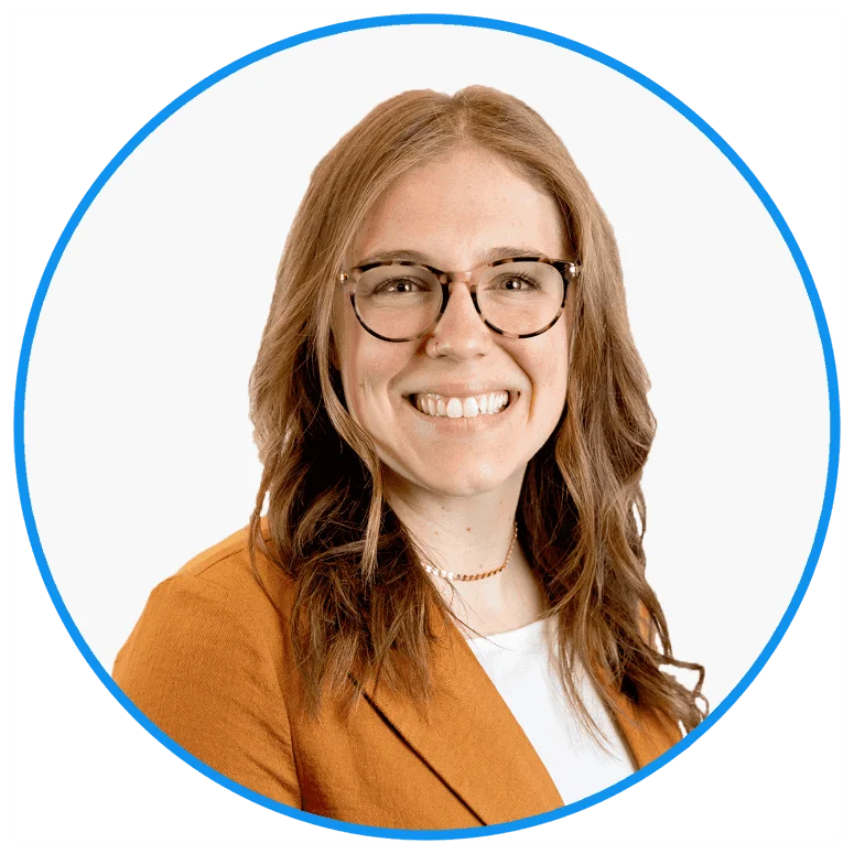 Professional young woman wearing glasses and orange blazer, smiling confidently in a modern corporate headshot with blue circle background.