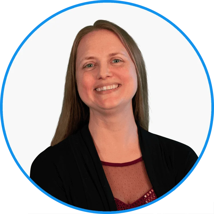 Professional portrait of a smiling businesswoman with long hair, wearing a black jacket and red blouse, isolated on white with a blue circle frame.