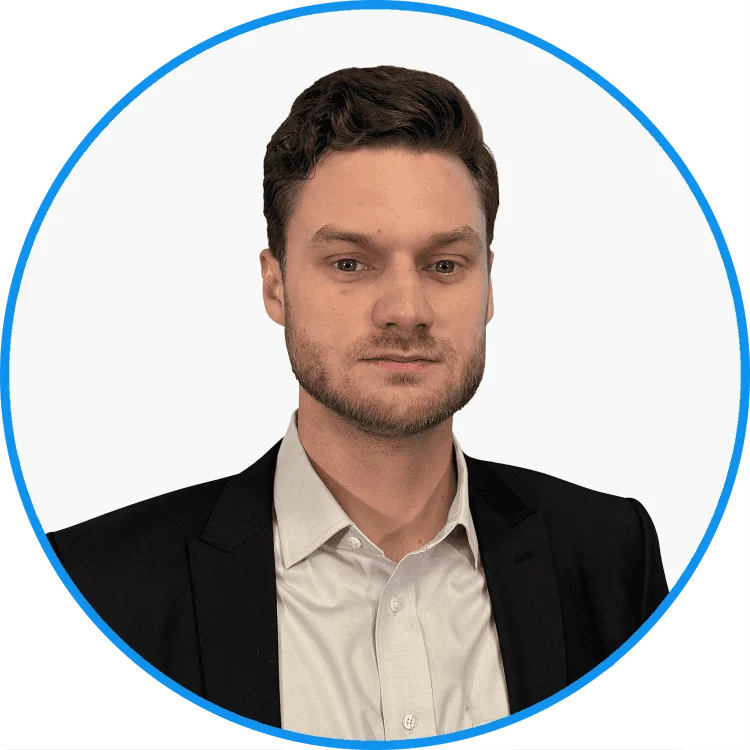 Professional young man with light brown hair, wearing a black suit and white shirt, set against a plain background, framed within a blue circle.