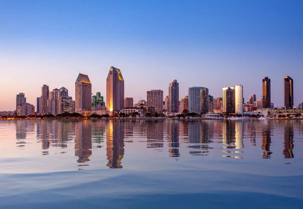 Sunset illuminating the tall skyscrapers of San Diego in California from Centennial Park in Coronado with artificial water reflection